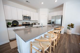 a kitchen with white cabinets and a gray counter top