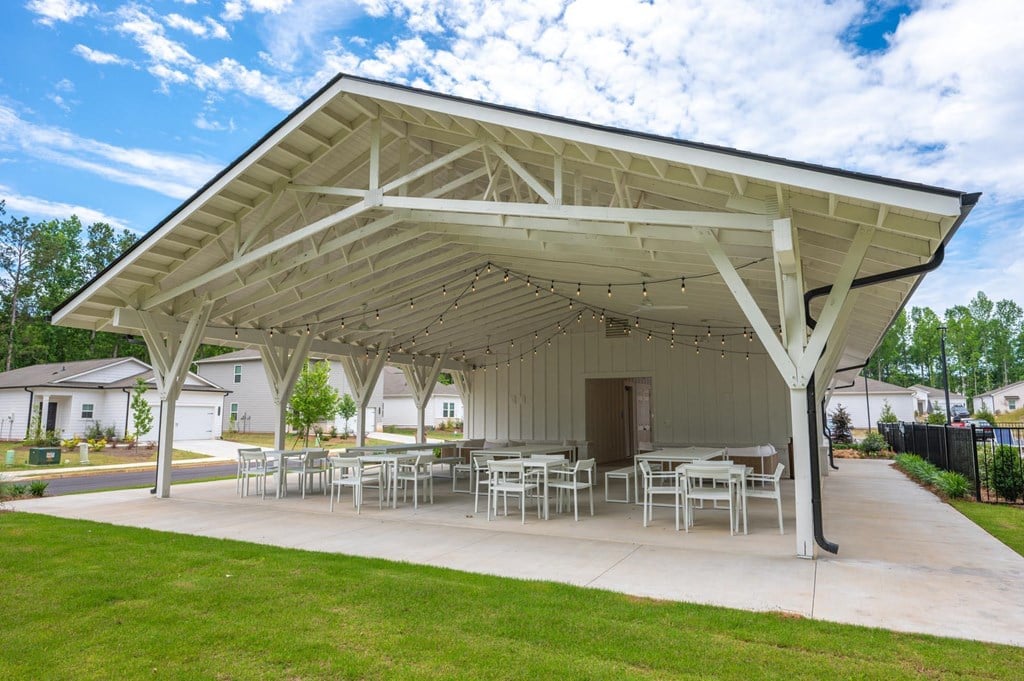 a pavilion with tables and chairs on a concrete patio