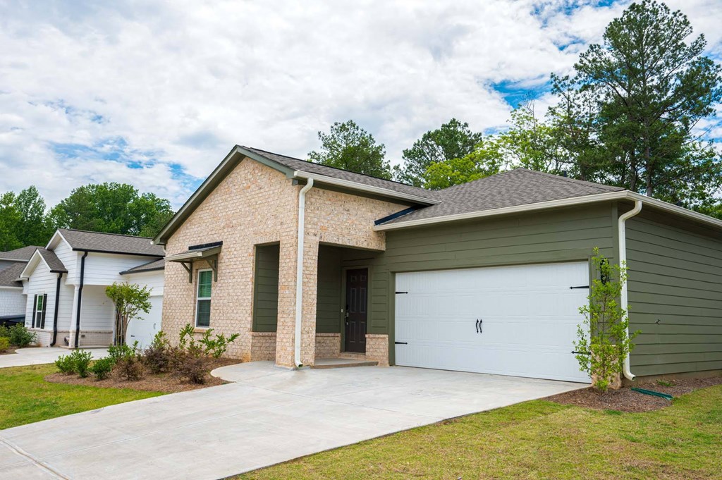 a house with a concrete driveway and a green garage door
