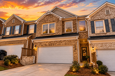 A house with a garage and a car parked in front.