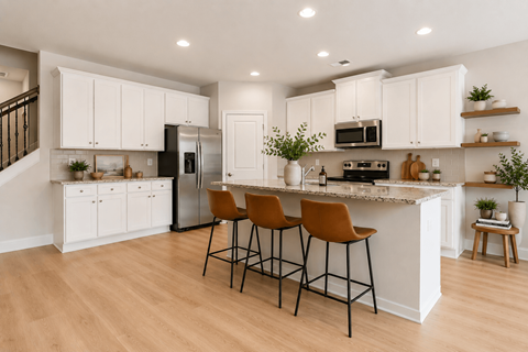 A kitchen with white cabinets and a black refrigerator.