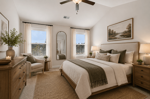 A bedroom with a large bed and a ceiling fan.