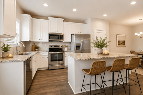A kitchen with white cabinets and a marble countertop.