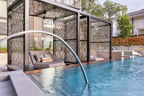 a pool with a fence around it next to a house