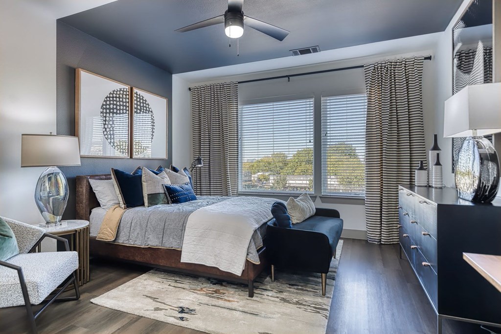 a bedroom with a bed and two windows