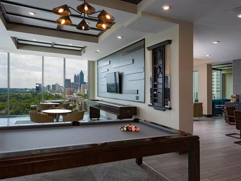 a pool table in a living room with a city view
