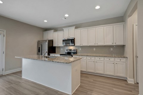 a kitchen with white cabinets and a granite counter top