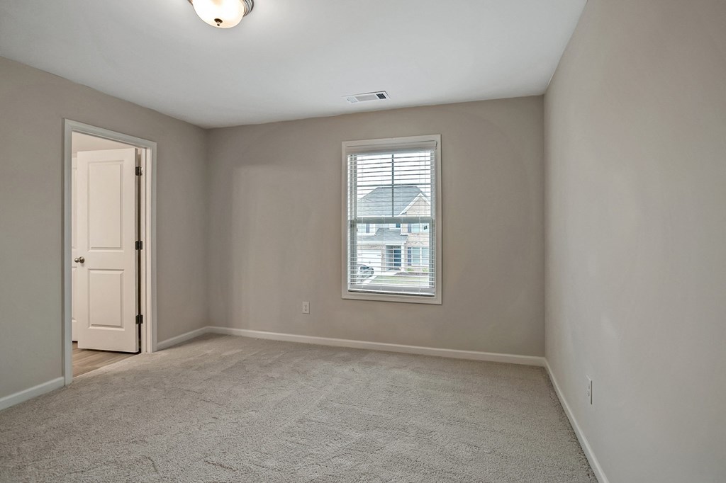 an empty living room with a window and a door