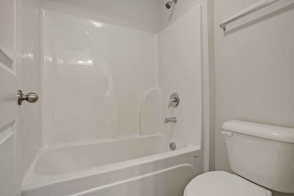 a bathroom with a toilet and a tub and a sink