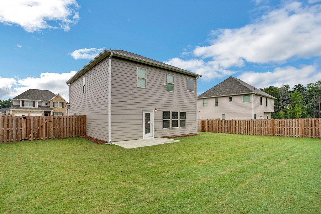 the backyard of a house with a yard and a fence