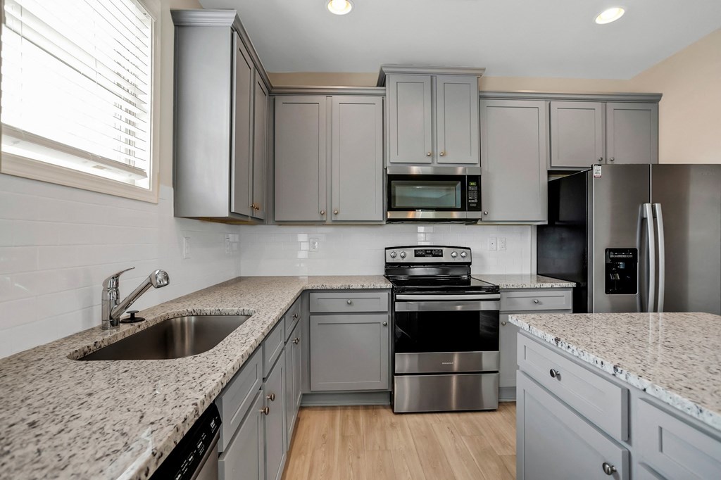 a kitchen with granite counter tops and stainless steel appliances
