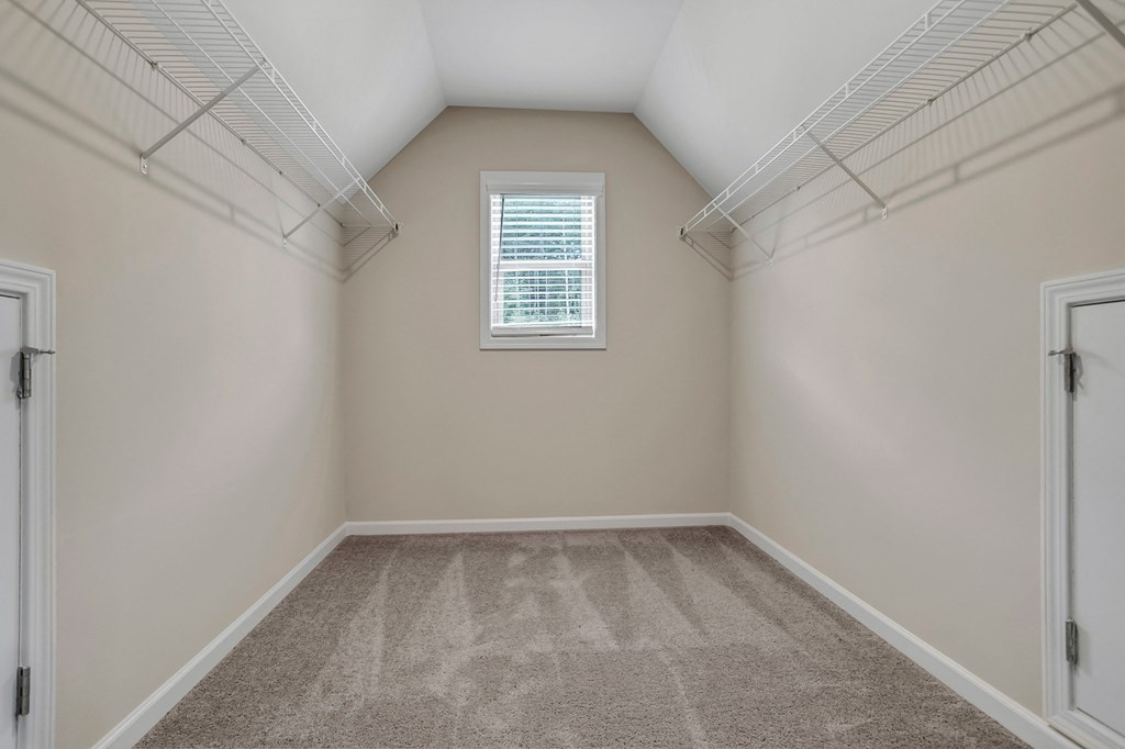 an empty room with a closet and a window