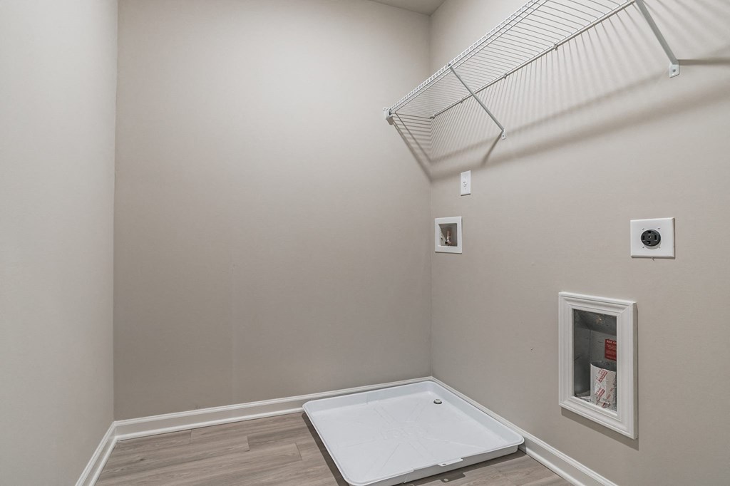 a white room with a shower in the floor and a white wall with a window