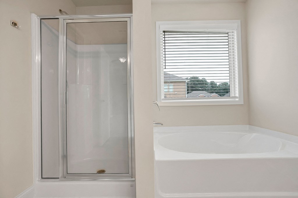 a bathroom with a tub and a shower and a window