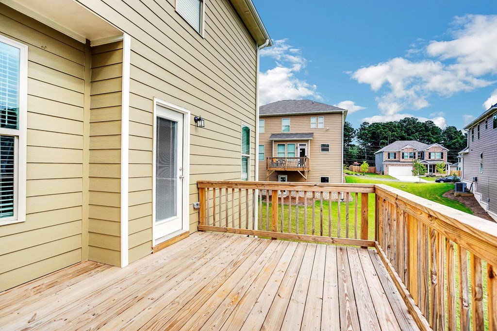 the deck of a home with a view of the yard and neighboring houses