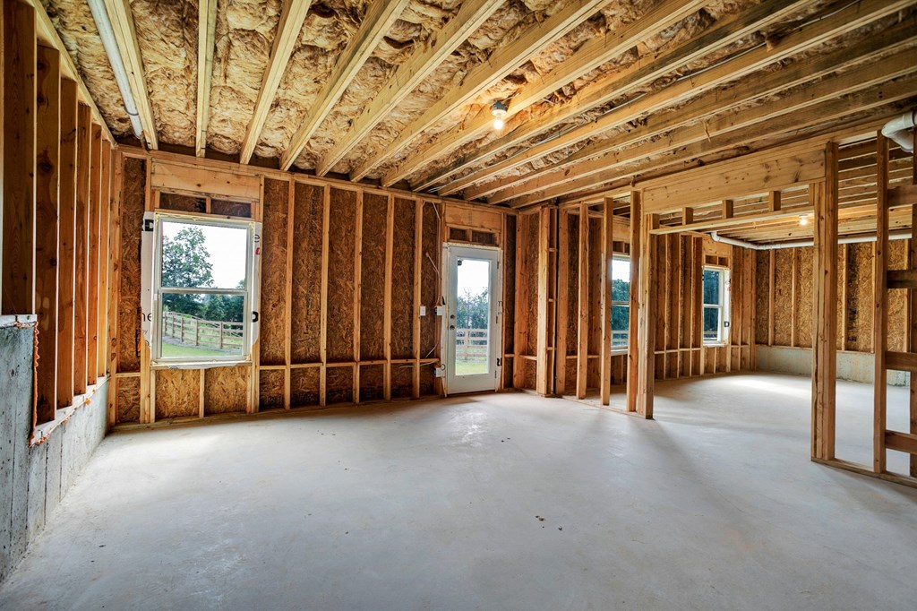 the living room of a house being remodeled with wood studs and exposed insulation