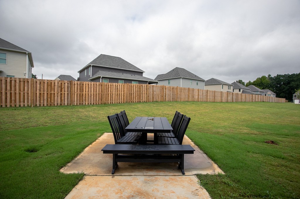 a patio with a table and chairs in a backyard