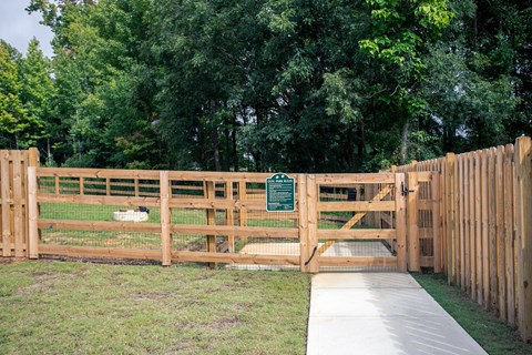 a wooden fence with a sign on it in front of some trees
