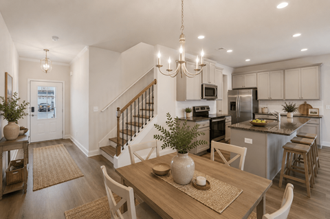 A modern kitchen with a dining table set for two.