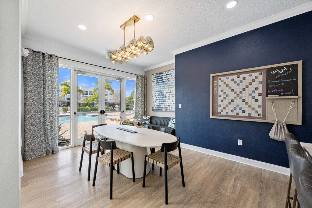 A dining room with a table and chairs and a chandelier.