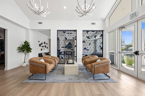 A living room with a row of brown chairs and a grey rug.