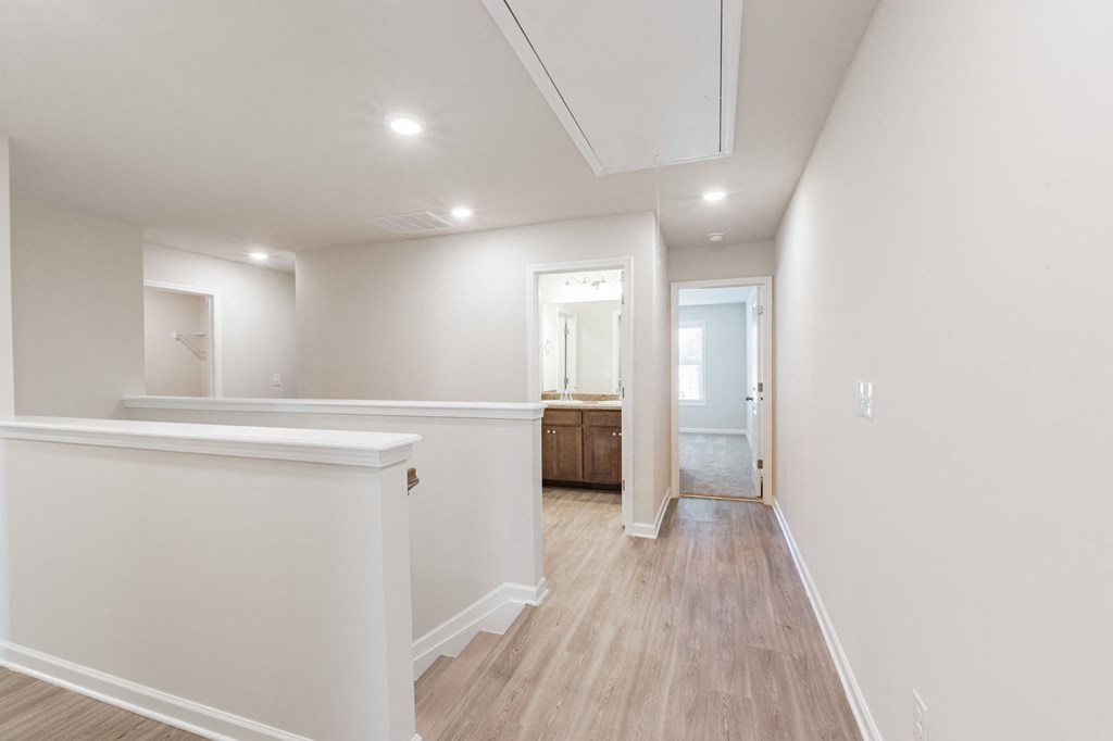 a renovated living room with white walls and wood floors