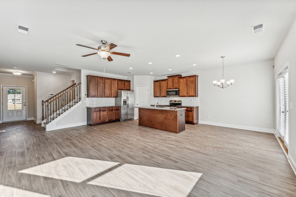 Living room and kitchen view, with espresso colored cabinets.