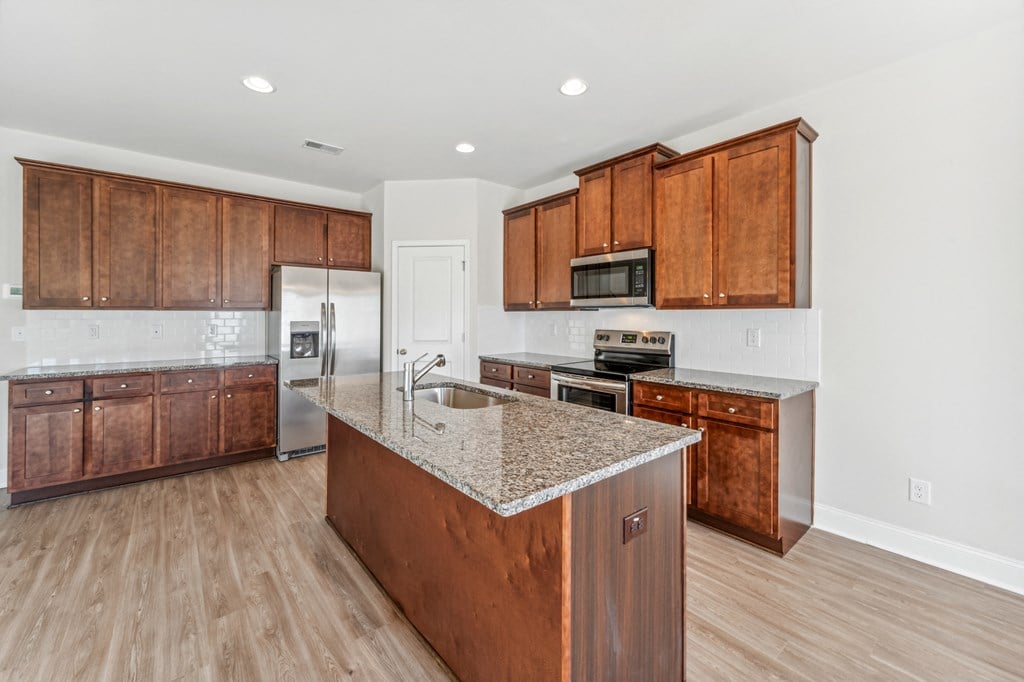 Kitchen with espresso colored cabinets, island and large pantry.