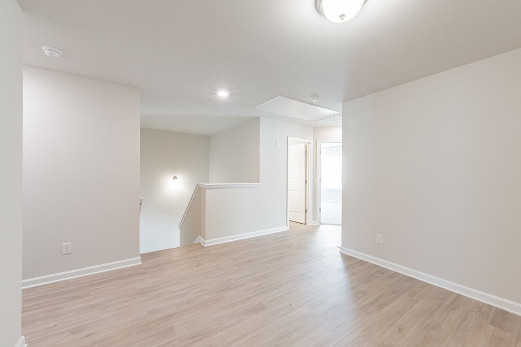 a living room with a hardwood floor and white walls