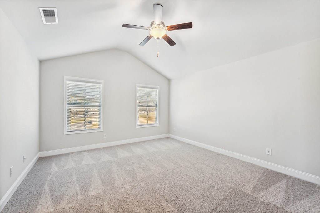 the living room of an empty house with a ceiling fan