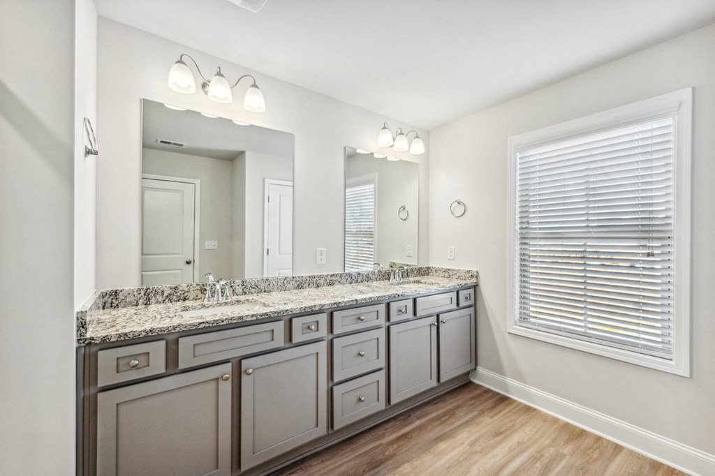 a bathroom with white cabinets and a large mirror and a sink