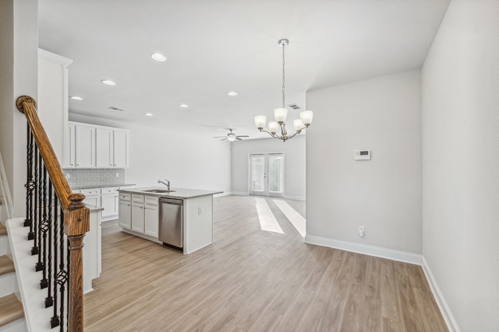 dining area next to kitchen island with white cabinet color scheme.