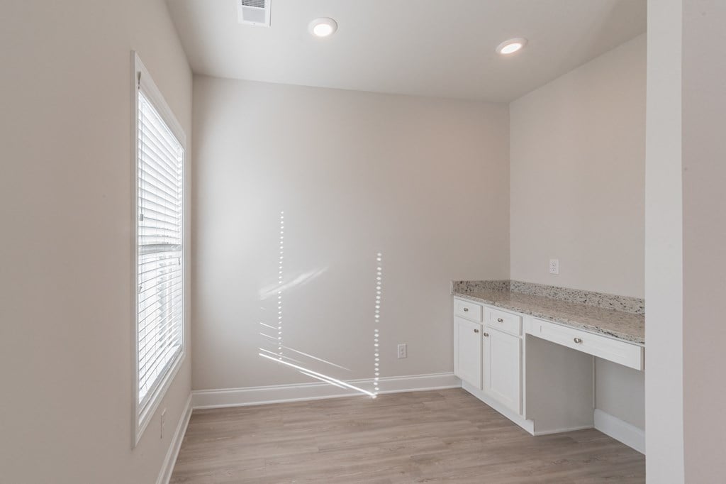 built in desk area with white cabinets.