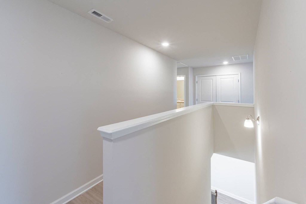 a living room with white walls and a white staircase