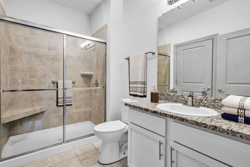 A bathroom with a toilet, sink, and shower.