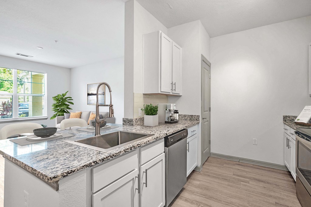 A kitchen with a marble countertop and stainless steel appliances.