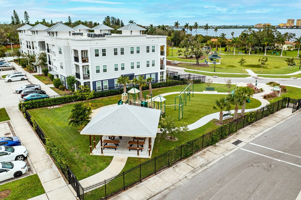 A white building with a black fence and a gazebo in front.