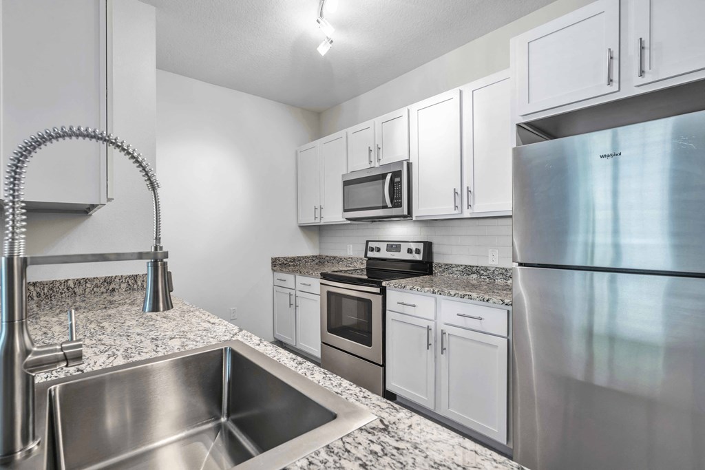 A modern kitchen with stainless steel appliances and white cabinets.