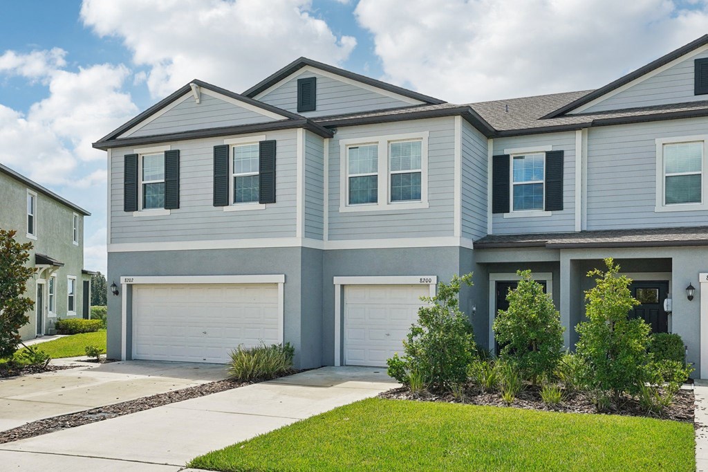 a blue and white house with two garage doors