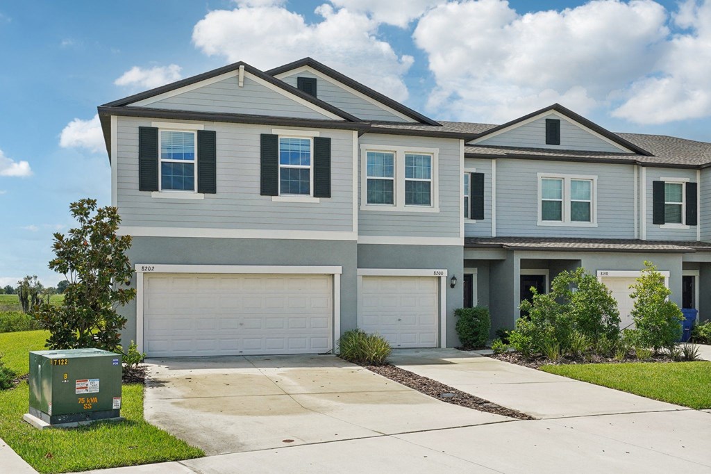 a white house with two garage doors and a driveway