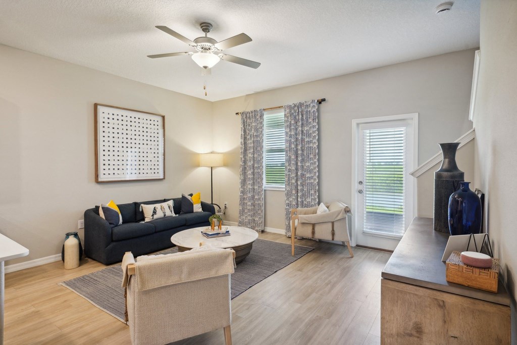 an open living room with a ceiling fan and a window