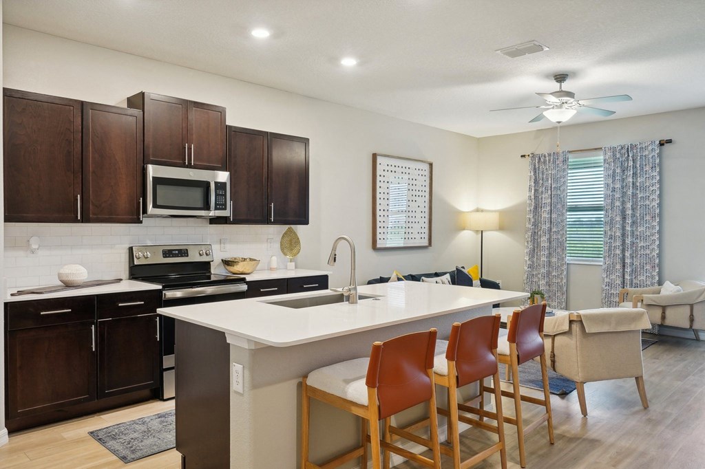 a kitchen with a large island with chairs in front of it