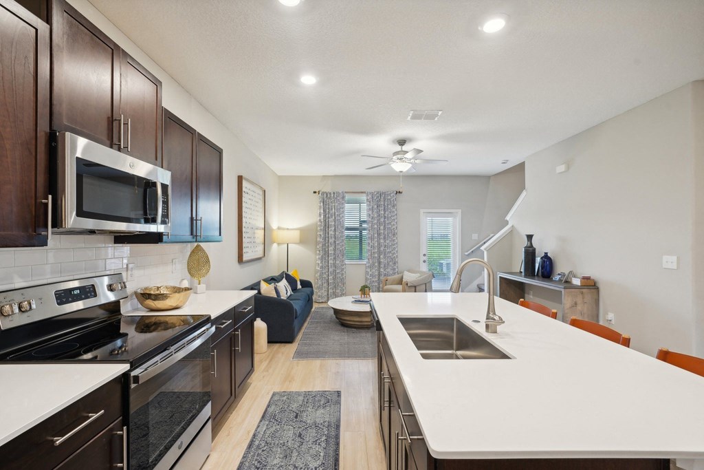 an open kitchen and living room with a large white counter top