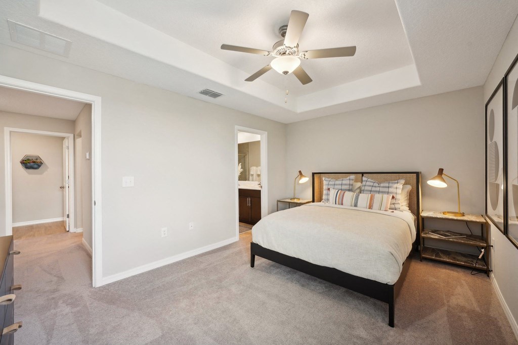 a bedroom with a large bed and a ceiling fan