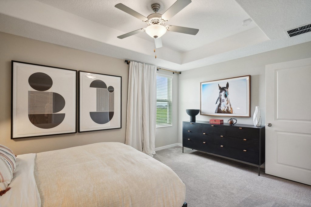 a bedroom with a bed and a ceiling fan