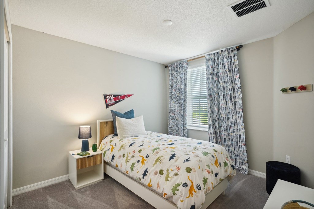 a bedroom with a bed and a window with curtains