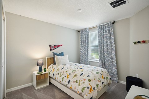a bedroom with a bed and a window with curtains