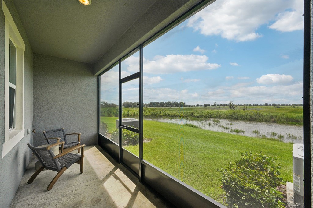 a balcony with a view of a field and a river