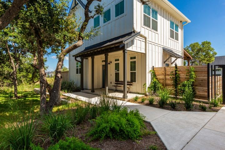 a white house with a porch and a sidewalk