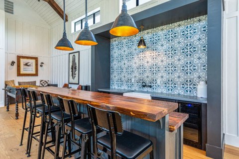 a long bar in a restaurant with black chairs